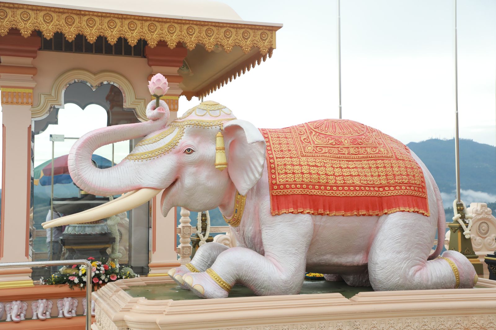 A white sculpted elephant draped in an ornamented red cloth