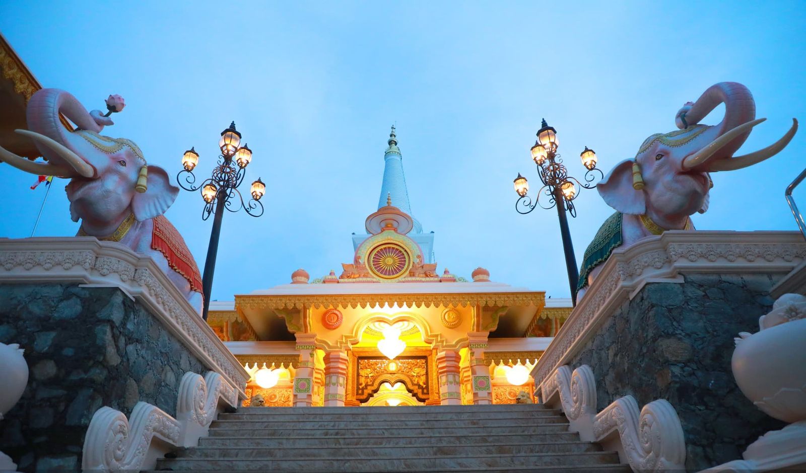 Ornamented stairway with elephant sculptures leading up to the stupa