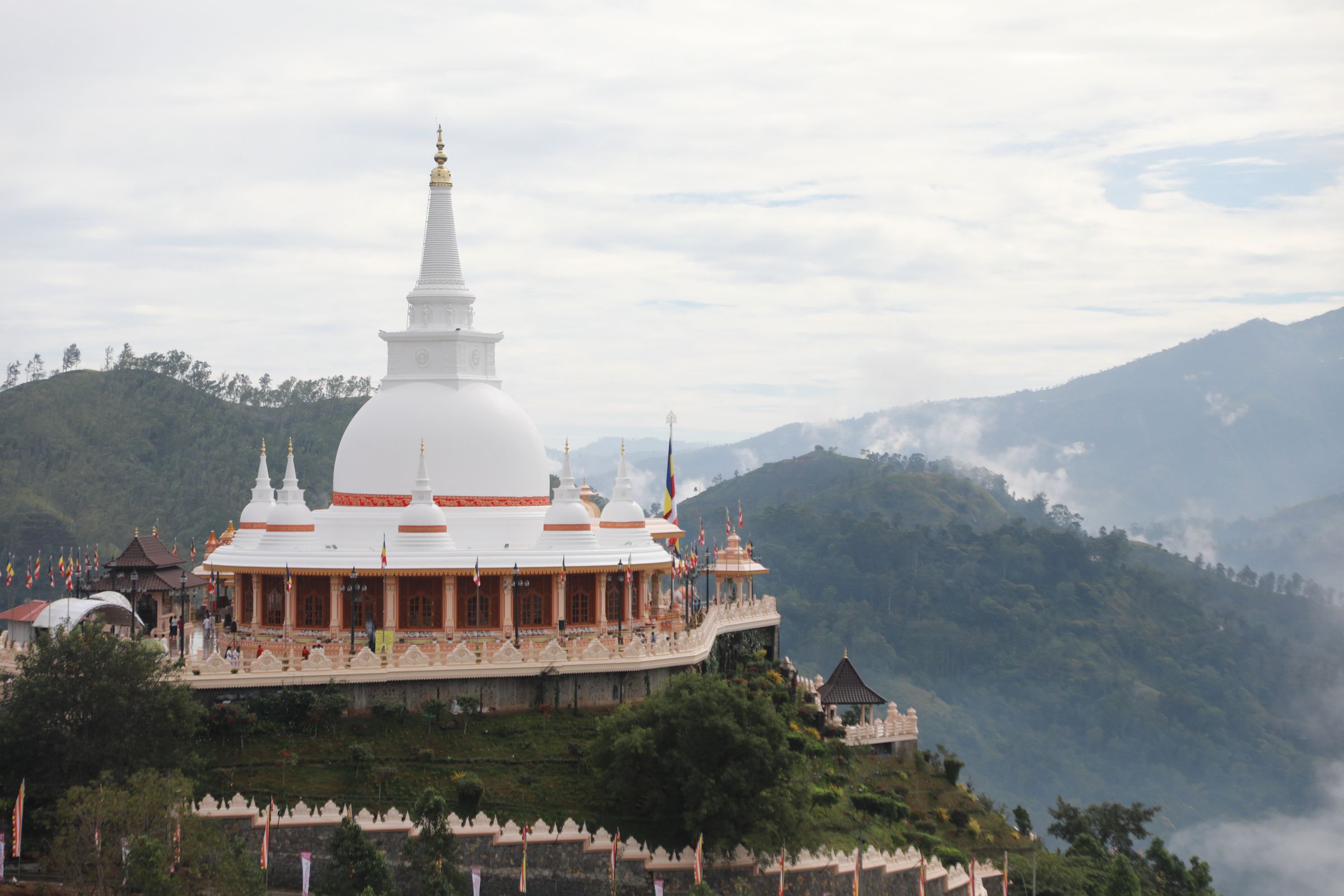 The Seven Buddhas Great Stupa among clouds and mountain ridges in the Ella hills
